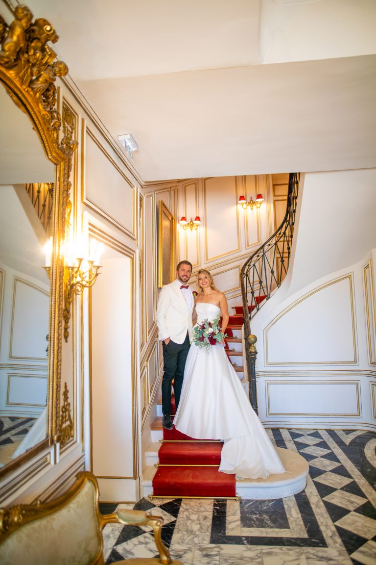 Mariés élégants posant sur l’escalier majestueux du Château de Robernier en Provence, lors d’un mariage de luxe dans le Sud de la France.