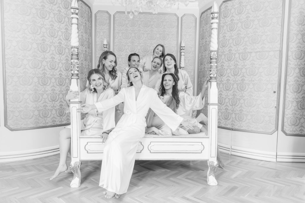 Photo en noir et blanc de la mariée et de ses demoiselles d'honneur en peignoirs, rassemblées dans une chambre du Château de Robernier.