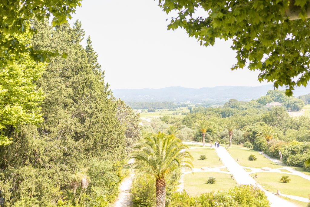 Vue plongeante sur les jardins du Château de Robernier et la campagne environnante, baignée de lumière estivale.