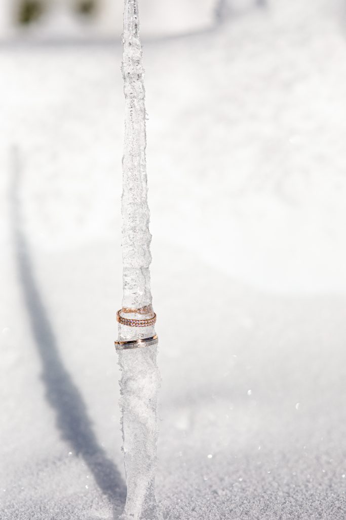 Alliances de mariage en or serties de diamants posées sur un pic de glace, photographiées en lumière naturelle par Studio JOLY Photographie lors d’un mariage d’hiver élégant.